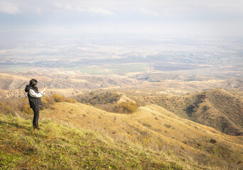 Female person takes a photo from black mountain viewpoint in Vashlovani