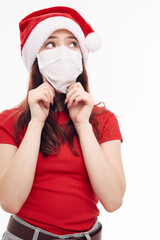 Fototapeta na wymiar girl wearing a medical mask red t-shirt christmas hat christmas holiday