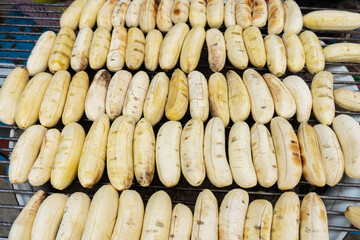 street food in Thailand. The wire rack with peeled bananas is ready to cook. Fried bananas. Street food market