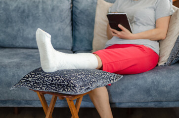 The middle aged woman with broken leg at home