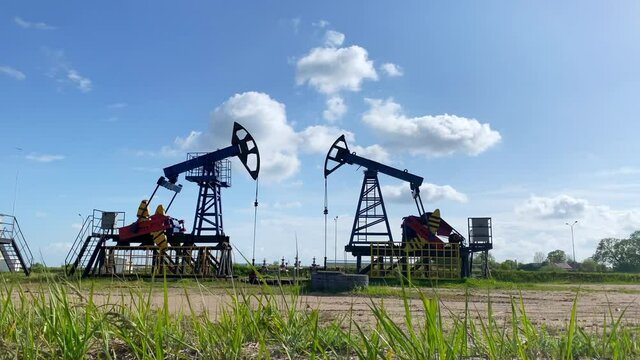 Working oil pumps from an oil field. Industrial equipment. Oil production. Silhouette.