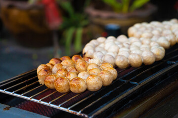 Meatballs are fried on an open-air stove at a street food market in Asia