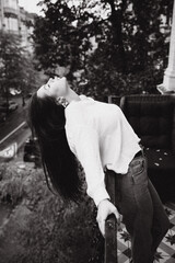 Photoshoot of a beautiful girl in a white shirt on the balcony