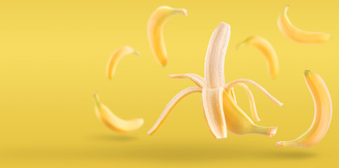 Fresh ripe peeled banana falling in the air. banana isolated on yellow background. fresh fruit levitation concept.