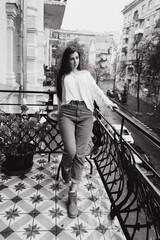 Obraz premium Photoshoot of a beautiful girl in a white shirt on the balcony