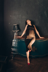 Obraz na płótnie Canvas Fashion photoshooting in a photo studio of a beautiful girl in a black dress