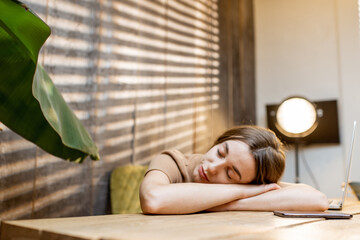 Sleepy woman at the workplace at home. Cozy workplace at home, the concept of fatigue from work at home