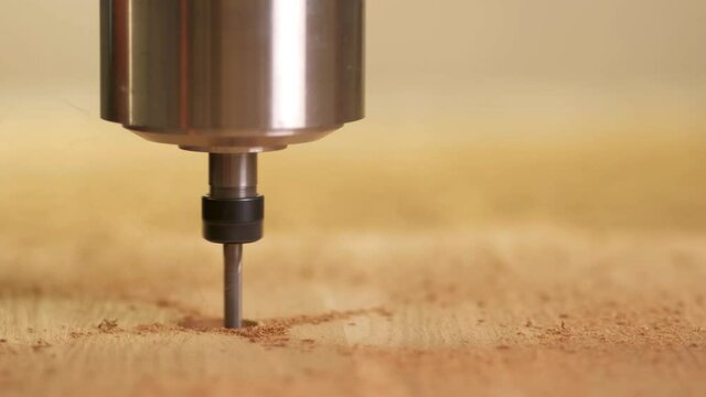 the cnc machine drills a hole in the wood. wood carving. Head close up