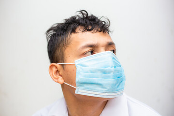 Portrait of young asian man wearing face protective medical mask for protection from virus disease