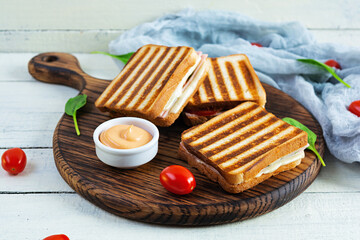 Club sandwich with ham, tomato, cheese and spinach. Grilled panini