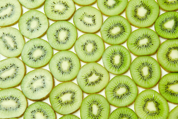 Clean fresh half cuted slices of green kiwi fruit rings stack pattern background