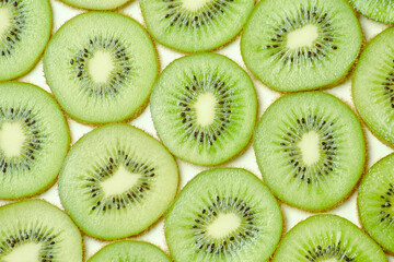 Clean fresh half cuted slices of green kiwi fruit rings stack pattern background