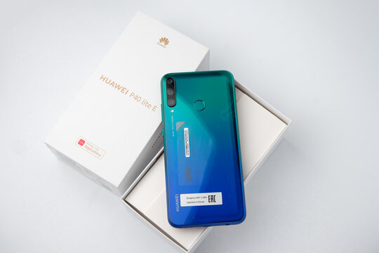 St. Petersburg, Russia, December 23, 2020: unpacking new products from Huawei, Huawei P40 lite E smartphone in blue color in the original packaging isolated on a white background