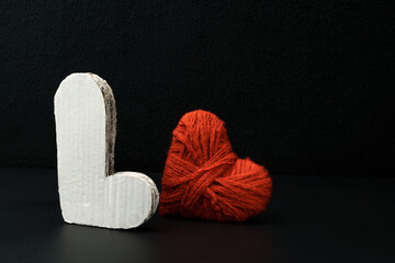 Volumetric letter L and a heart on a black . Valentines day card