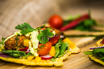 Corn tortilla stuffed with fresh vegetables and falafel. The food in the restaurant. Food styling and restaurant meal serving.