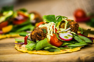 Corn tortilla stuffed with fresh vegetables and falafel. The food in the restaurant. Food styling and restaurant meal serving.