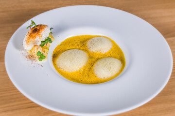 Pumpkin soup with espuma and herbs. The food in the restaurant. Food styling and restaurant meal serving.