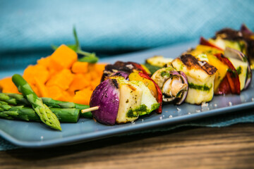 Grilled skewer with vegetables and mushrooms on plate with asparagus. The food in the restaurant. Food styling and restaurant meal serving.