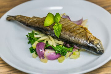 Grilled trout on roasted vegetables. The food in the restaurant. Food styling and restaurant meal serving.