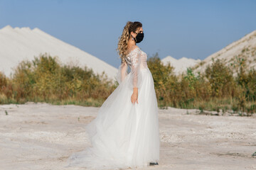Bride in wedding dress with medical mask at coronavirus covid-19 quarantine period.
