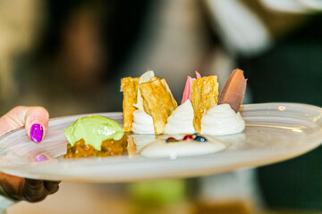 close-up on the hand of a waiter carrying food sweet dessert. Food styling and restaurant meal...