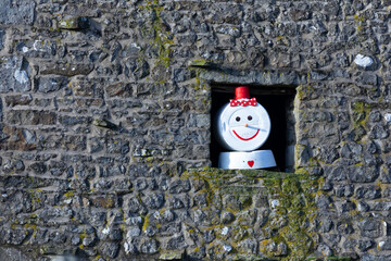 Snowman made of buckets in barn opening