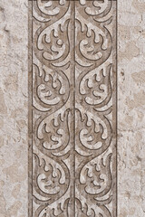 Ornamental print on the granite surface. Vintage ornament on the stone. Embossed drawing. Close-up. Stone texture. Pattern on the stone. Embossed pattern. Wallpaper. Tile. Close-up of seamless texture