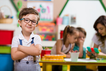 Preschooler posing at camera in classroom.