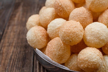Deep fried puris for pani puri dish on wooden table, copy space