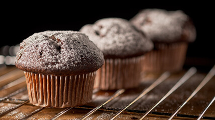 Three muffins sprinkled with powdered sugar