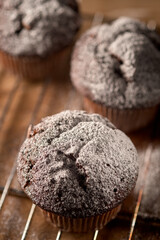 Three muffins sprinkled with powdered sugar