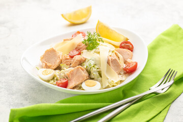 Salad with baked salmon. A large portion of salad with red fish, fresh vegetables, eggs, cherry tomatoes and lemon.