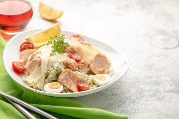 Salad with baked salmon. A large portion of salad with red fish, fresh vegetables, eggs, cherry tomatoes and lemon.