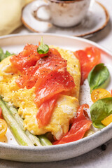 Fried eggs with green asparagus and salmon, cherry tomatoes and fresh spinach.