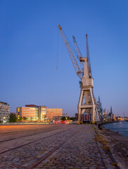 Old harbor cranes after sunset in the center of Antwerp.