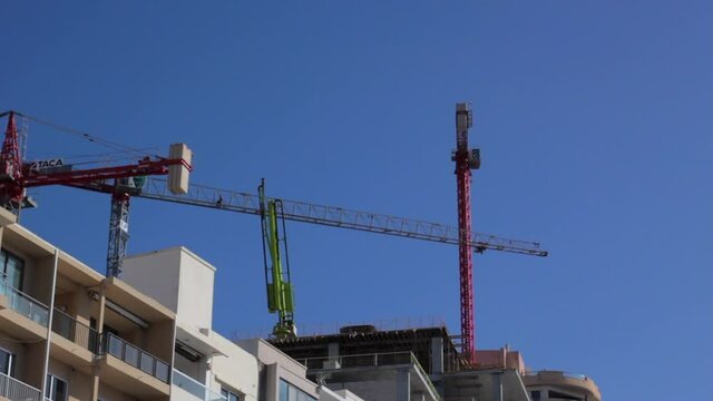 Construction crane on building site moving in Malta