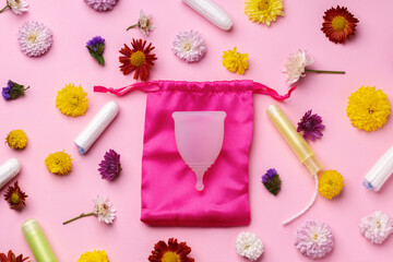 Menstrual cup and tampons on floral pattern background