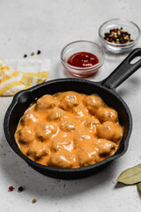 Swedish meatballs in creamy sauce in cast iron skillet. space for text.