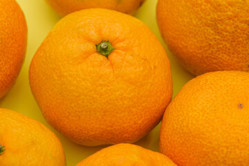 Tangerines close up. Ripe tangerines on a yellow background. Healthy food with vitamins. Fruit for immunity
