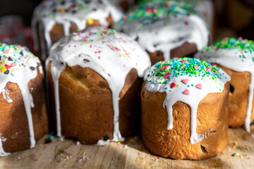 Many Traditional eastern europe Russian and ukrainian Easter cake kulich decorated with sweet sugar icing on wooden table morning sunlight ray. Tasty handmade christian orthodox holiday paska bread