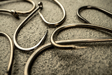 Fishing hooks on concrete textured background macro