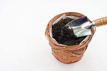 Soil in flower pot and gardening tools on white background