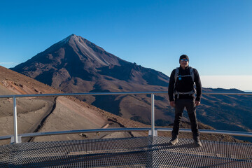 Beautiful shot of a male standing on a balcony facing the Pico de Orizaba Volcano in Mexico