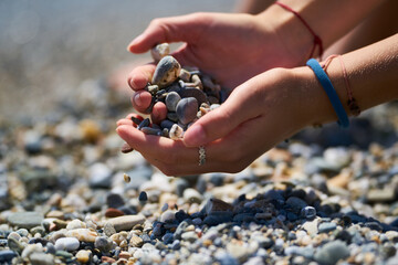 gils hands holding small stones of a beach in Málaga, Andalucía and playing with the sand