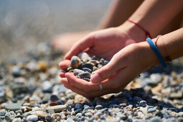 gils hands holding small stones of a beach in Málaga, Andalucía and playing with the sand