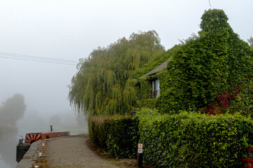 Fototapeta na wymiar house along the canal in the fog