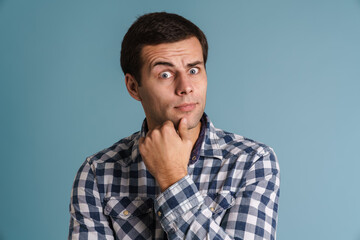Pensive casual young man thinking isolated