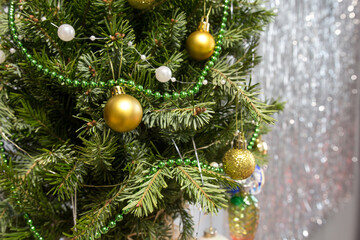 green decorated christmas tree with golden balls on gray background