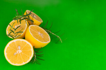 Fresh sliced ​​in half lemons on a green background. Copy space.