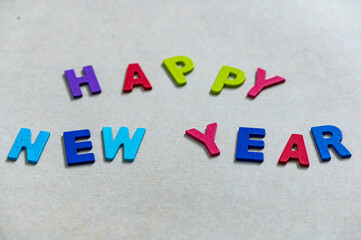 Happy new year font art colorful texting for greeting or celebrate card with light brown background, Sensitive Focus